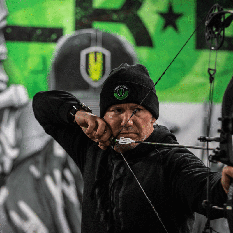 John Dudley using a peep sight on a compound bow for archery.