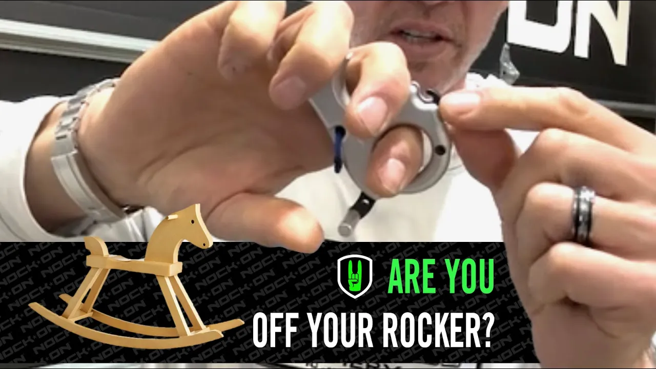 ARE YOU OFF YOUR ROCKER? If so you’re killing accuracy! 1 John Dudley demonstrating the proper hand position on a handheld release aid, with a caption that reads ‘Are You Off Your Rocker?