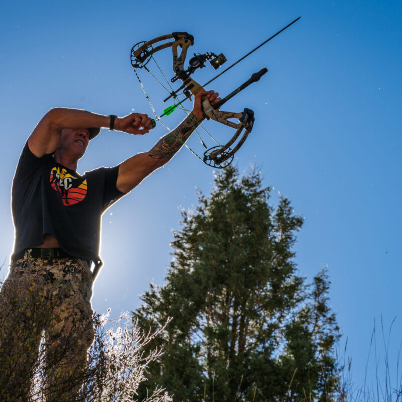 A low angle photo of John Dudley as he begins to draw his bow.
