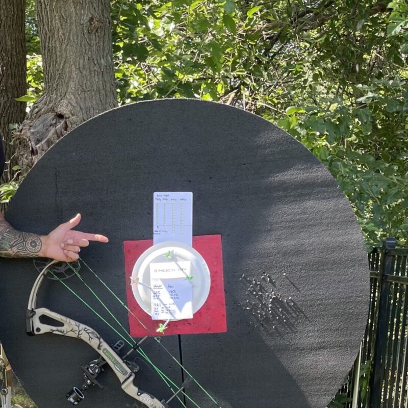 John Dudley pointing to an archery target.