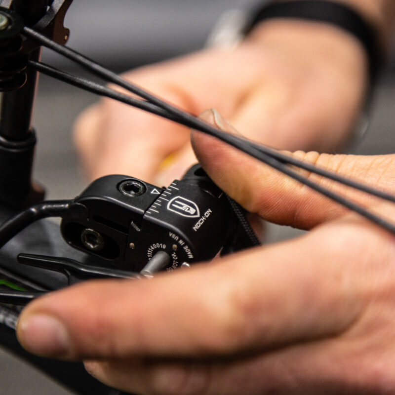 Close up of an archery rest on a compound bow being modified.