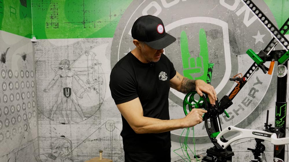 Bow Specs Not Matching Up? Post-String-Change Adjustments Made Easy 8 Marking a bow cam for string replacement. This technique helps archers maintain proper axle-to-axle length and brace height after changing strings.