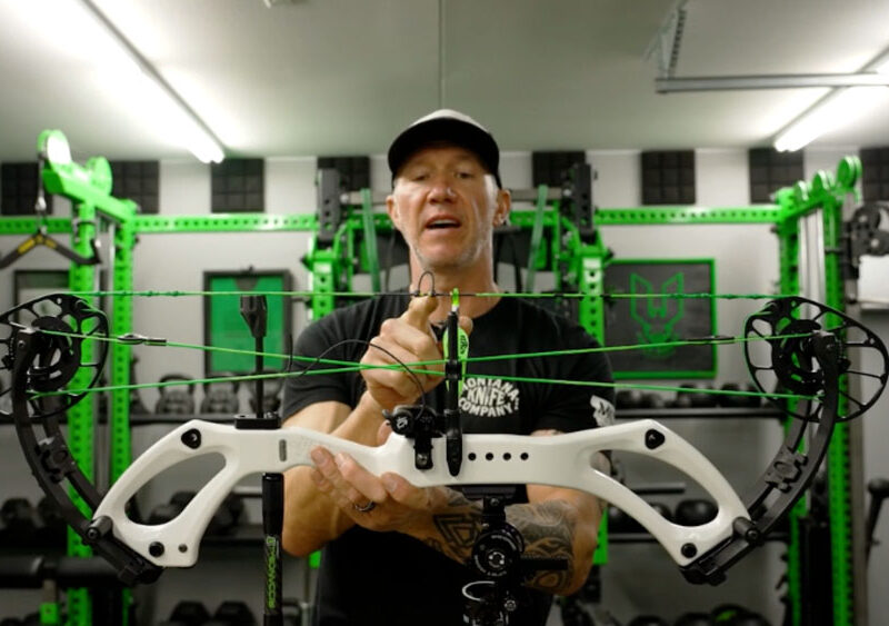 John Dudley adjusting a bow, highlighting the process of fine-tuning for arrow flight.